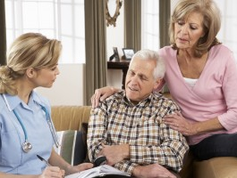 caregiver talking to elderly couple
