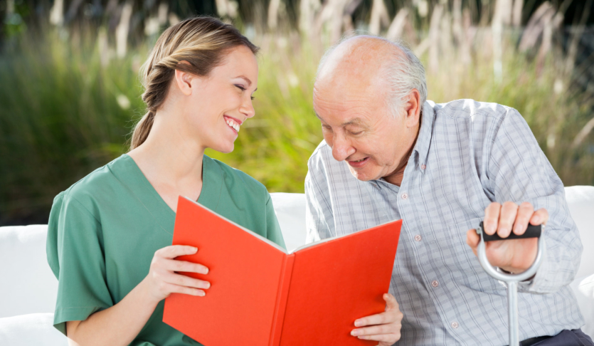 caregiving reading book to senior man